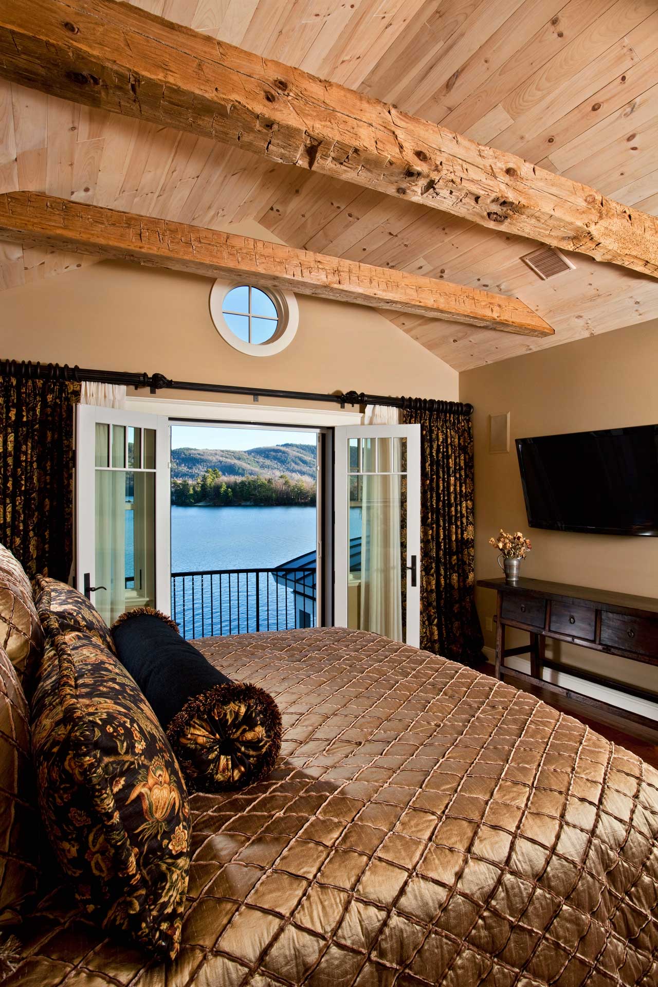 Photo of Brauner project, bedroom with lake view through open french doors and exposed wooden beams