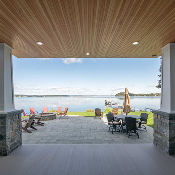 Panpramic view of the lake framed by classic craftsman-style stone-base tapered columns and a natural wood beadboard ceiling