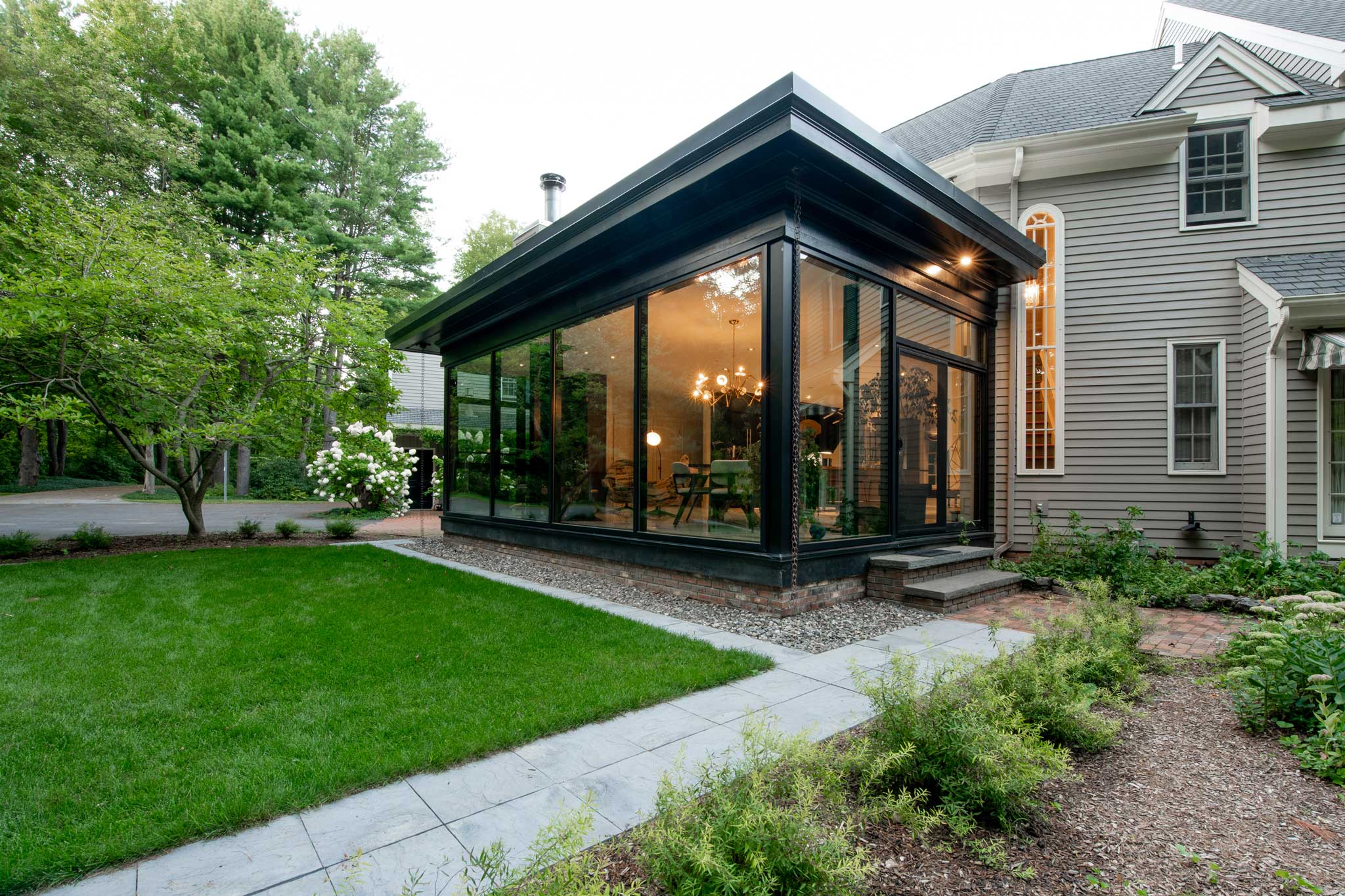 Angled view of home addition showing landscape and glass sides of the addition.